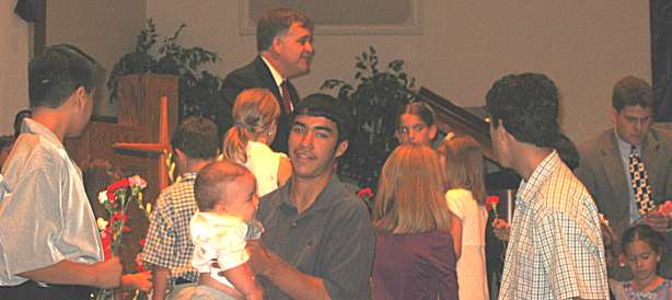 Pastor has children pass out single-stem flowers to all congregation mothers